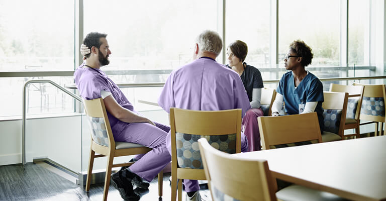 Médicos de diversas especialidades reunidos em uma mesa